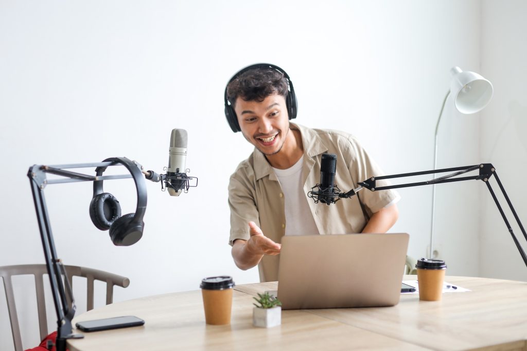 Presenter using a laptop and microphone